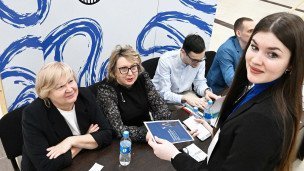Студентка у информационного стенда на ярмарке вакансий