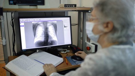 Врач-рентгенолог смотрит на экран на котором отображаются легкие пациента 