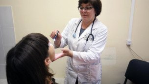 Врач-педиатр ведет осмотр пациентки