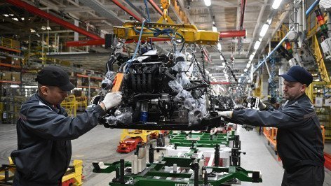 Рабочие за сборкой автомобиля на производственной линии