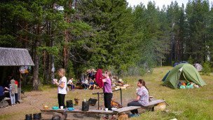 Отдыхающие туристы в лесу около кемпинга 