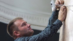 Мужчина устанавливает камеру видеонаблюдения