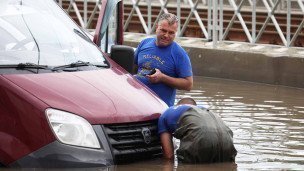 двое мужчин у затопленного автомобиля