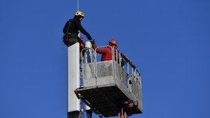 Рабочие монтируют базовую станцию сотовой связи