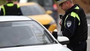 Сотрудник ГИБДД проверяет документы автовладельца на дороге
