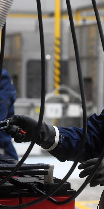 Рабочие в цехе завода по производству аккумуляторных батарей 