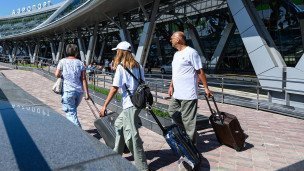 Пассажиры выходят из здания аэропорта