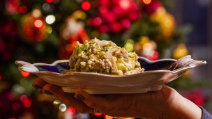 Салат Оливье на фоне новогодней елки