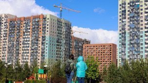 Горожане на фоне строящихся зданий жилого комплекса