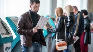 мужчина изучает брошюру с вакансиями на ярмарке трудоустройства