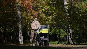 Женщина с ребенком гуляет в парке 