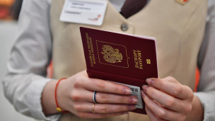 Загранпаспорт в руках сотрудника МФЦ