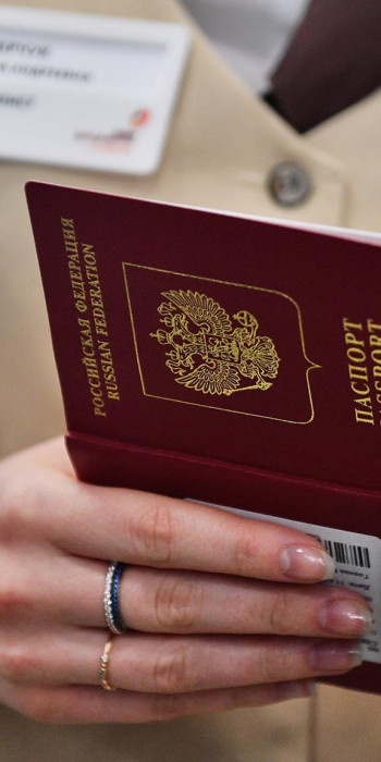 Загранпаспорт в руках сотрудника МФЦ