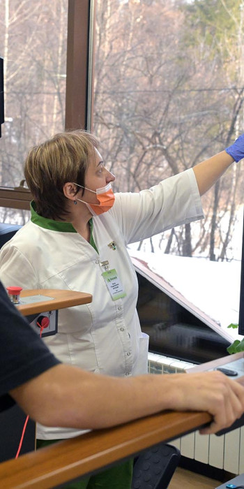 Медицинский работник помогает пациенту во время прохождения процедур 