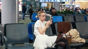 Девушка с телефоном в аэропорту
