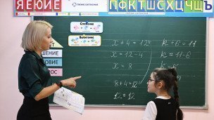 Учительница и ученики младших классов на уроке 