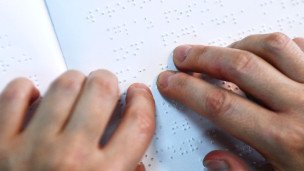 Руки читают азбуку Брайля