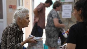 Пенсионерке помогает сотрудница в центре помощи 