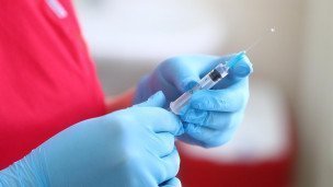 Медицинский работник держит шприц 