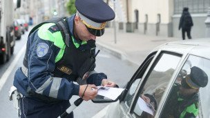 Сотрудник ГИБДД проверяет документы у водителя
