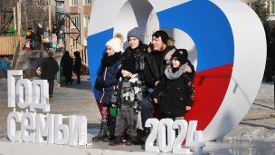 Многодетная семья на фоне российского триколора