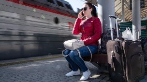 Женщина с багажом на железнодорожном вокзале
