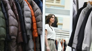 девушка смотрит в зеркало в бутике одежды