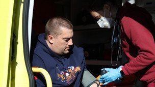 Фельдшер скорой помощи измеряет давление мужчине