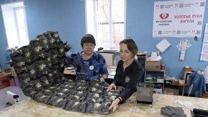 Участницы общественной  организации складывают готовый блиндажный матрас собственной конструкции