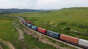 Поезд на железнодорожных путях с грузовыми контейнерами