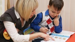 Преподаватель с учеником на уроке