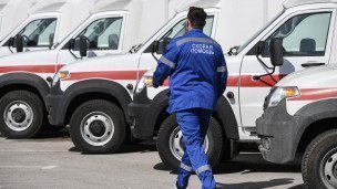 Сотрудник скорой помощи рядом с автомобилями скорой помощи