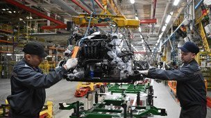 Рабочие за сборкой на производственной линии