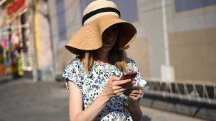 Девушка с телефоном на улице летом