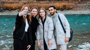 chetvero-studentov-fotografiruyutsya-na-fone-gornoj-reki