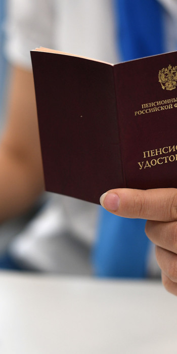 Сотрудник держит в руках пенсионное удостоверение