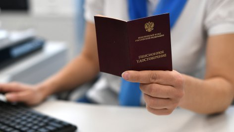 Сотрудник держит в руках пенсионное удостоверение