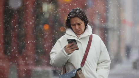 Девушка на улице с телефоном в снежную погоду