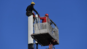 Рабочие монтируют базовую станцию сотовой связи