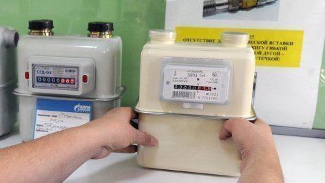 Продавец-консультант держит в руках газовый счетчик 