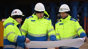 Строители держат чертеж