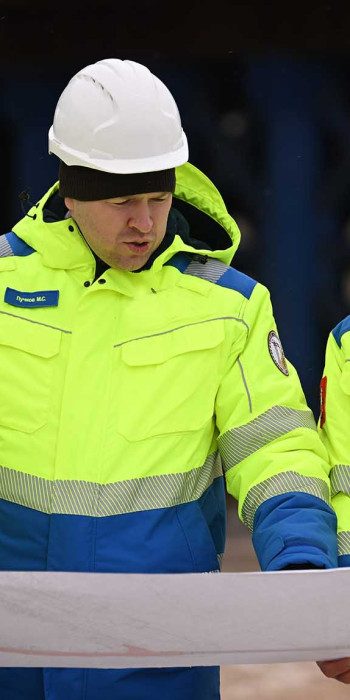 Строители держат чертеж