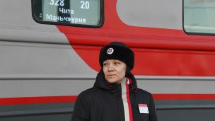 Проводница около пассажирского поезда 