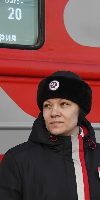 Проводница около пассажирского поезда 