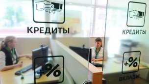 Менеджеры банка за стеклянной перегородкой на которой написано Кредиты Проценты