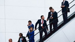 Предприниматели в деловых костюмах на эскалаторе 