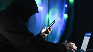 Мужчина держит в руках мобильный телефон