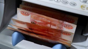 Счетная машинка пересчитывает деньги