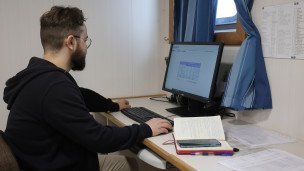 Мужчина работает дома на компьютере 