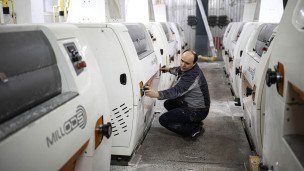 Рабочий настраивает аппарат в цехе производства